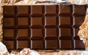 a bar of premium chocolate laying on a bed of gold leaf.