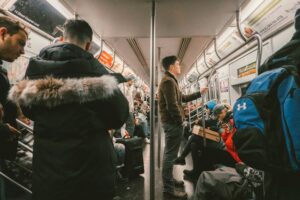Inside a New York City Subway train, specifically the 14 Street-Canarsie Local line, also known as the L train. 